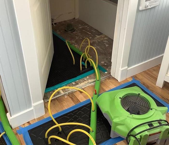 Water damage in a bathroom in Flagstaff, AZ, with our specialty drying equipment that we use for hardwood floors