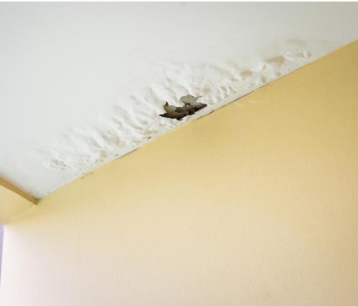 a white ceiling showing signs of peeling paint from water damage